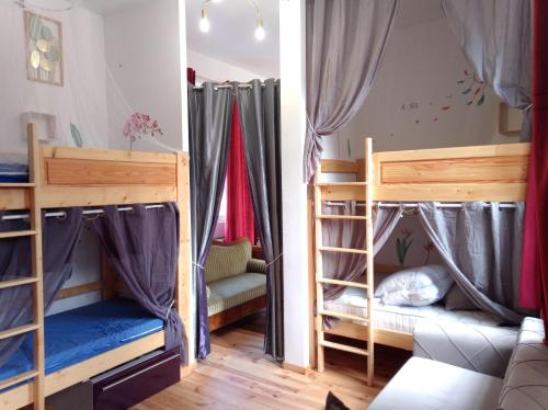 une chambre avec deux lits superposés et un canapé dans l'établissement Gîte groupe cycliste via rhona Les Capucines, à Saint-Vallier