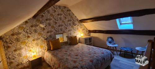 a bedroom with a bed and a wall with flowers at La Petite Maison de l'Oze in Verrey-sous-Salmaise