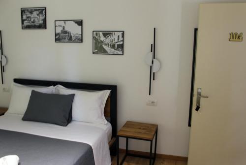 a bedroom with a bed and some pictures on the wall at Guest House AmaDes in Gjirokastër