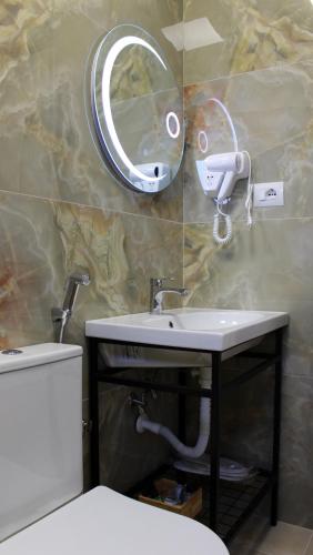 a bathroom with a sink and a mirror on the wall at Guest House AmaDes in Gjirokastër
