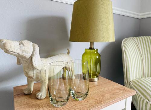 a table with two wine glasses and a lamp at Bettys in Hunstanton