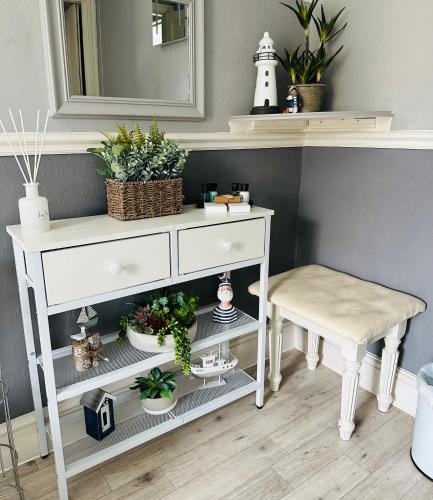 a white dressing table with a stool and a mirror at Bettys in Hunstanton