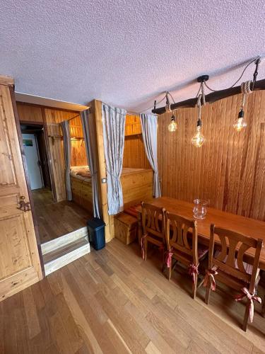 une salle à manger avec une table et des chaises en bois dans l'établissement Appartement Front de neige, à Isola