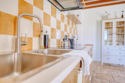 une cuisine avec un évier en acier inoxydable et un comptoir dans l'établissement Le Mousseau - proche du Zoo - tranquillité absolue, à Saint-Aignan