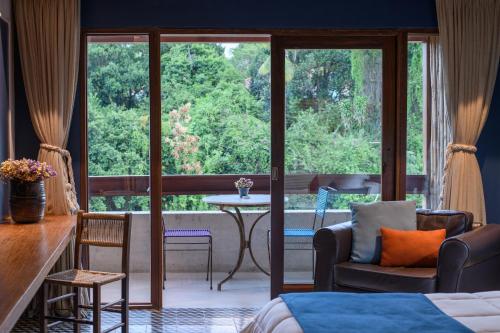 a bedroom with a bed and a large window with a table at Hotel Canto das Águas - Roteiro de Charme in Lençóis