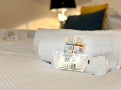 a white bed with two bottles of medicines on it at BeeFree Thermen und Golf3 I Free Parking I Balcony in Pocking