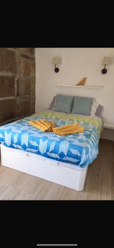 a bed with a blue and white comforter on it at Casa da Chã! in Chã