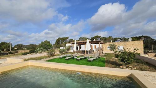 een zwembad in een tuin met een huis bij Estudio S'ALGA in Sant Francesc Xavier
