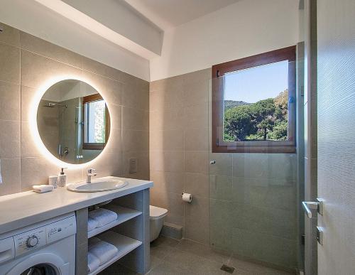 baño con lavabo y ducha con ventana en Ben’s Apartments, en Agia Paraskevi