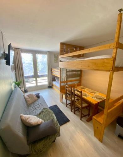 - un salon avec un canapé et des lits superposés dans l'établissement Appartement Au plaisir - Front de neige, Antarès, à Villarembert