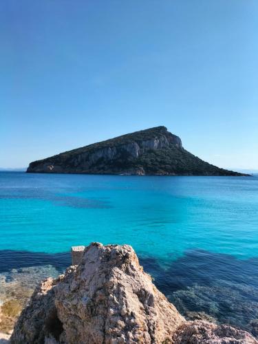 a rock in the water with an island in the background at Lilly's house in Murta Maria
