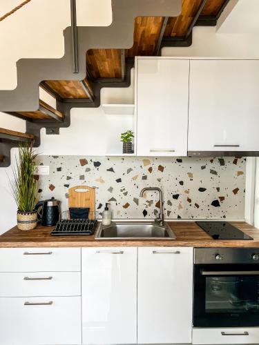 a kitchen with white cabinets and a sink at LOUTRA VILLAS in Agia Paraskevi