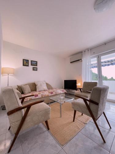 a living room with a couch and a table at SeaSunset in Sveti Stefan