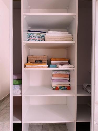 a closet with white shelves and folded towels at SeaSunset in Sveti Stefan