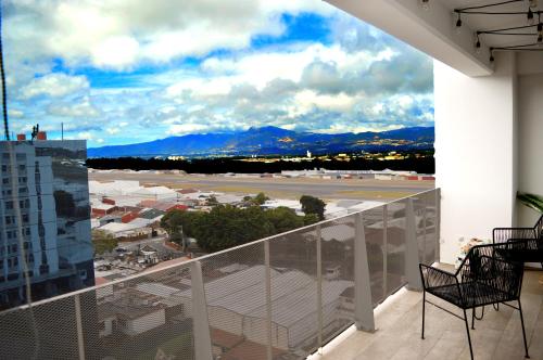 einen Balkon mit Stühlen und Blick auf den Flughafen in der Unterkunft Bertiz Cozy Jacuzzi in Guatemala