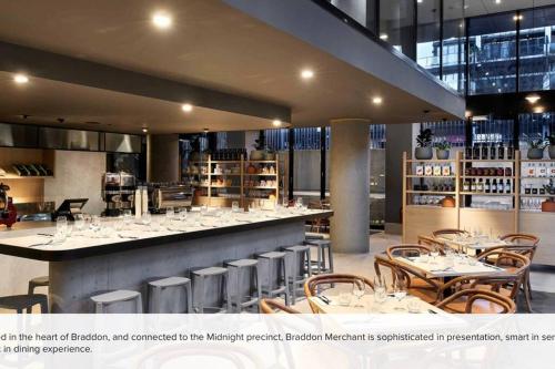 a restaurant with a bar with tables and chairs at Midnight Luxe 2BR 2Bath Apartment 507 in the heart of Braddon L5 Views Pool Sauna Gym Wifi in Canberra