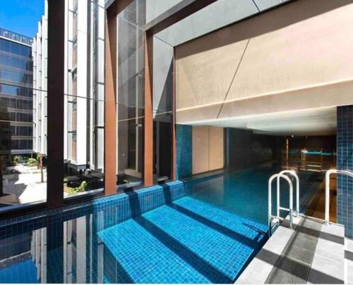 a swimming pool on the side of a building at Midnight Luxe 2BR 2Bath Apartment 507 in the heart of Braddon L5 Views Pool Sauna Gym Wifi in Canberra