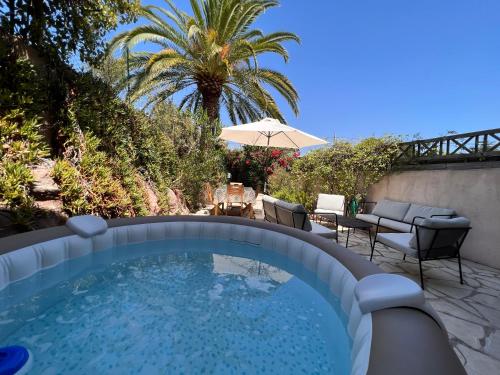 - une piscine avec des chaises et un parasol sur la terrasse dans l'établissement SIMONE, Appartement maison, quartier calme, grande terrasse, SPA, barbecue, 2 chambres, à Fréjus