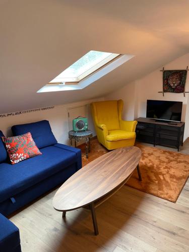 sala de estar con sofá azul y silla amarilla en Lisbon Soul Surf Camp, en Cascais