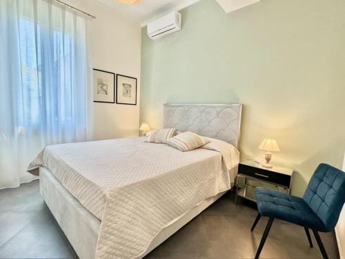 a bedroom with a large bed and a blue chair at Villa Matteotti Garden Lux 200mt by the sea in Forte dei Marmi