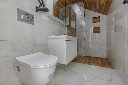 a white bathroom with a toilet and a shower at NEAR BY THE LAND OF LEGENDs , PRİVATE POOL , VİLLA LARİSA in Belek