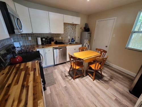a kitchen with a wooden table and a table and chairs at Sweet home Alabama! in Mobile