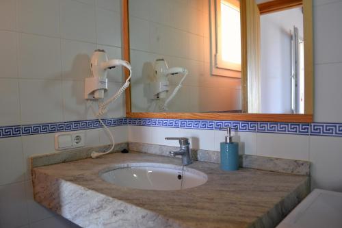 bagno con lavandino e specchio di Estudio SAVINA a Sant Francesc Xavier