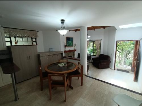 uma cozinha e sala de estar com mesa e cadeiras em Casa Campestre Poblado para 8 em Medellín