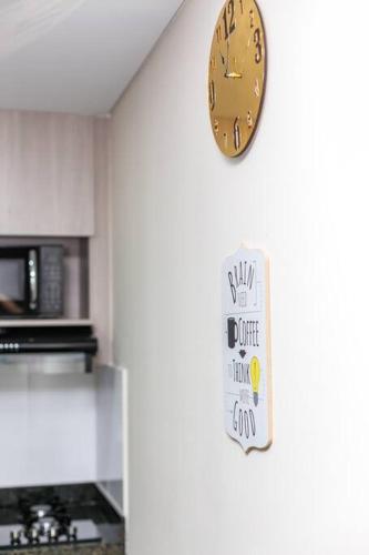 a clock hanging on a wall next to a kitchen at Apartment in Medellin in Sabaneta