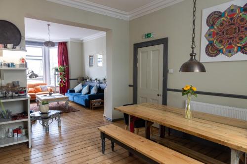 ein Wohnzimmer mit einem Tisch und einem blauen Sofa in der Unterkunft Zen House By The Sea In Margate in Kent
