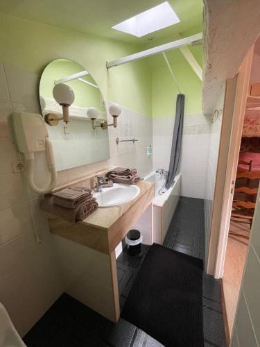 une salle de bain avec un lavabo, un miroir et une baignoire dans l'établissement Les Hauts de Saint Jacques - Cognac, à Cognac