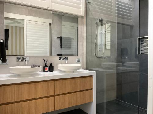 ein Bad mit 2 Waschbecken und einer Dusche in der Unterkunft Hope Island Little Paradise in Gold Coast