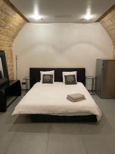 une chambre avec un grand lit blanc avec deux oreillers dans l'établissement Superbe loft au coeur de Paris, à Paris