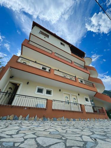 a building with balconies on the side of it at Friends House - Borsh Hotel in Borsh