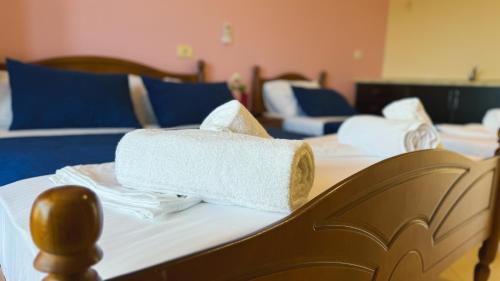 a pile of towels sitting on top of a bed at Friends House - Borsh Hotel in Borsh