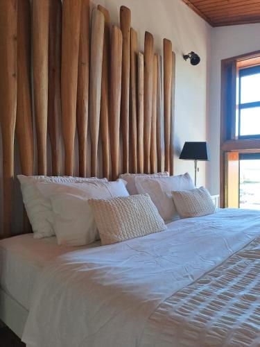 a bedroom with a large bed with a wooden headboard at SaberAmar Charme in Aveiro