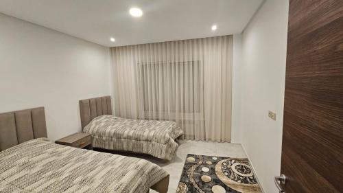 a hotel room with two beds and a window at Le flamand du lac 2 in La Goulette