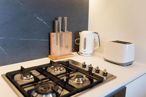 a stove top oven sitting on a counter with a toaster at Apartment next to public station, BoxHill Central, 2 Bedrooms, free parking and wifi in Box Hill