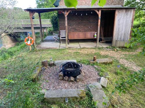 een tuin met een vuurplaats in de tuin bij Wye Riverside Lodge in Llandrindod Wells