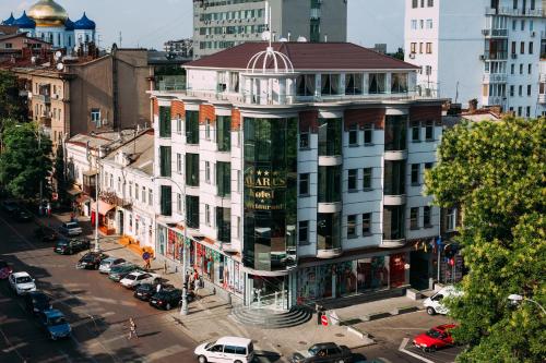 a large white building on a city street with cars at Alarus Luxe Hotel in Odesa