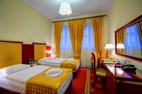 a hotel room with two beds and a desk at Hotel Holiday Park in Warsaw