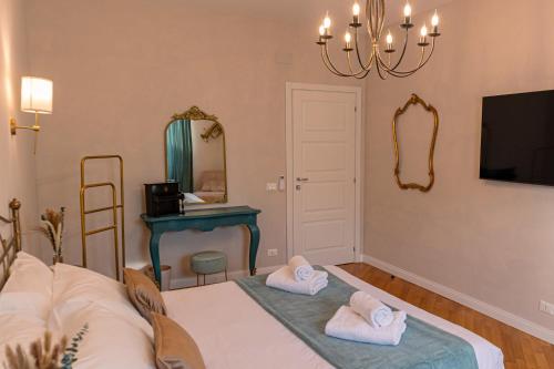 Zimmer mit einem Tisch, einem Spiegel und Handtüchern in der Unterkunft The Aristocats Apartment in Rom