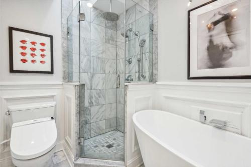 a bathroom with a shower and a toilet and a tub at Stunning Townhouse w Tennis & Pool in Southampton