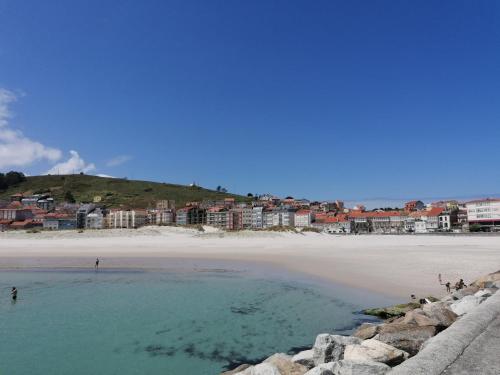 a view of a beach with buildings in the background at Apartamento Mar-Azul in Laxe