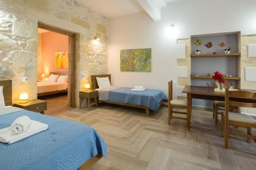 um quarto de hotel com duas camas e uma secretária em Eliana's Stone House em Benoudhianá