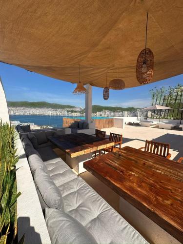 an outdoor patio with a wooden table and benches at LUXO Casa en Acapulco Zona Brisas Guitarrón con vistas espectaculares y 2 albercas in Acapulco