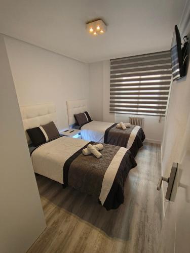 a bedroom with two beds and a window at Casa Logroñesa in Logroño