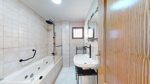 a white bathroom with a tub and a sink at El Olivo and Brisas Beach house in Gran Alacant