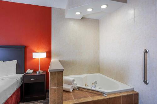 a bathroom with a bath tub next to a bed at Best Western Inn at Blakeslee-Pocono in Blakeslee