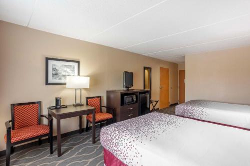 a hotel room with a bed and a desk and chairs at Best Western Inn at Blakeslee-Pocono in Blakeslee